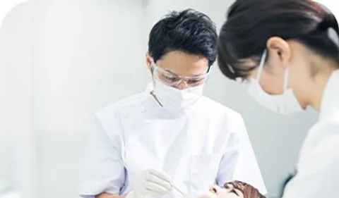歯科医とスタッフが患者を診療している様子