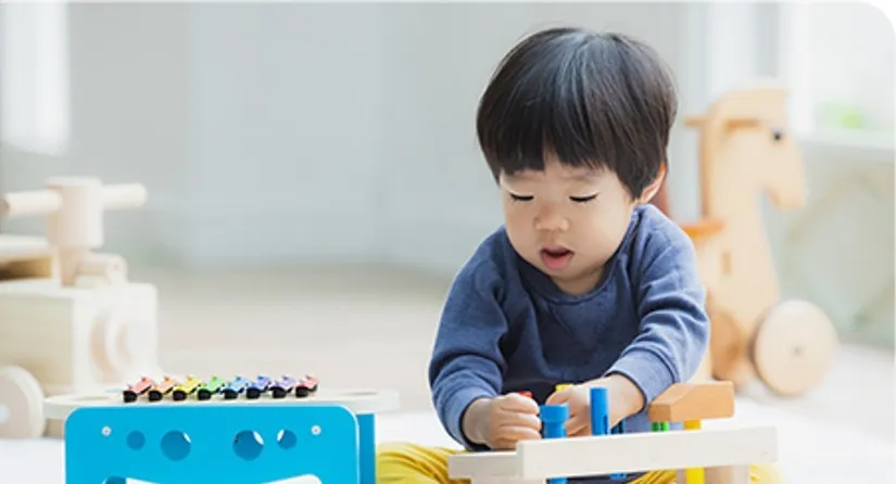 木のおもちゃで遊ぶ幼い子ども