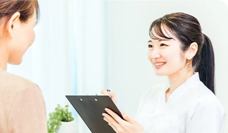スタッフが患者さんに笑顔で問診している様子