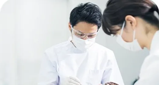 歯科医とスタッフが患者を診療している様子