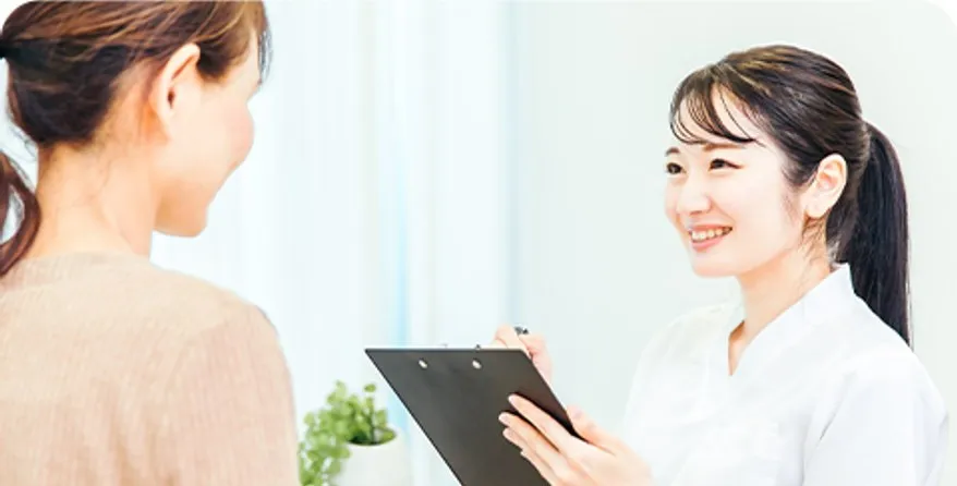 スタッフが患者さんに笑顔で問診している様子
