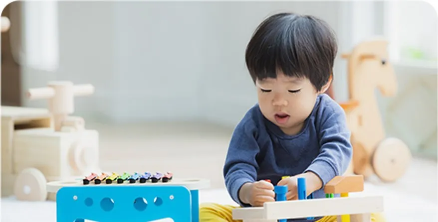 木のおもちゃで遊ぶ幼い子ども