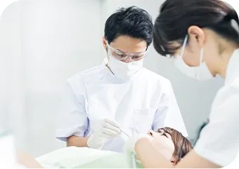 歯科医とスタッフが患者を診療している様子